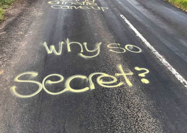 The 'why so secret?' message sprayed onto the road.