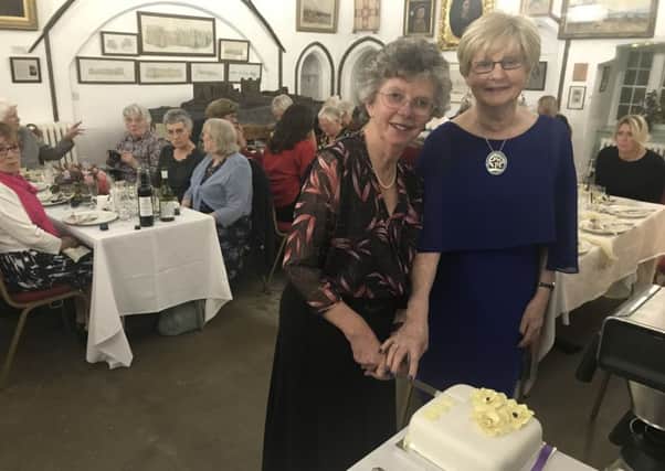 Christine Hutchinson, president of Bamburgh WI, and Hilary Robson, chairman of the Northumberland Federation of the WI, cut the cake to celebrate the 100th anniversdary of the first meeting of the Bamburgh group at Bamburgh Castle.