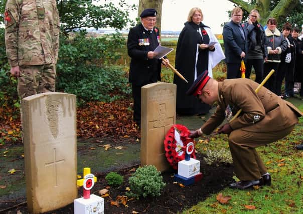 Welfare Officer Olly Roberts lays the wreath at the grave of Gunner H Whitfield, while Eric Turnbull recites the names of the fallen.
