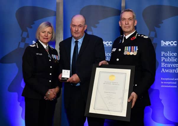 George Common, centre, receives his medal and certificate at the Police Public Bravery Awards.