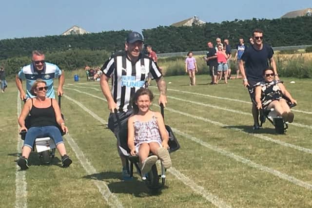 A wheelbarrow race at the fun day in Lowick in aid of the Sir Bobby Robson Foundation.