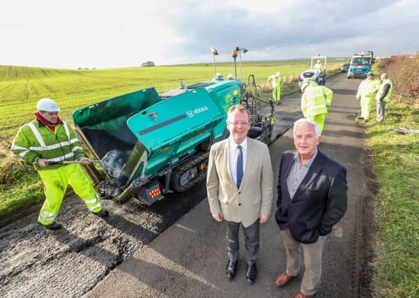 Council Leader Peter Jackson, left, and Coun Glen Sanderson with the new paving machine. Picture by Neil Denham