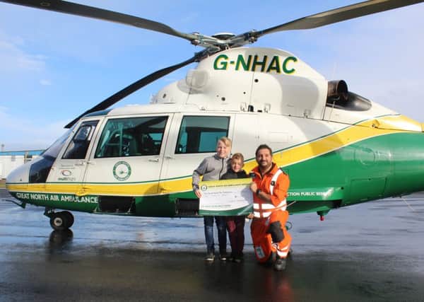 Owen and Alex Jenkinson present Â£2,000  to GNAAS paramedic Gordon Ingram.
