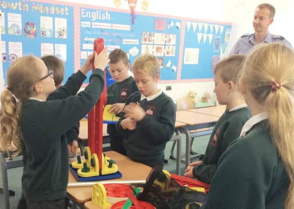 Pupils at St Paul's RCVA Primary School in Alnwick work with Flight Lieutenant Steve Morgan, from RAF Boulmer, on a STEM project.