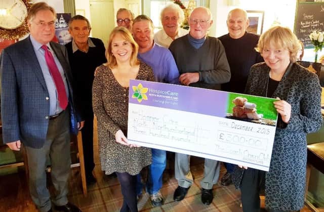 Jane Stratton, from HospiceCare North Northumberland, receives a Â£300 cheque from members of the Coach Inn Onion Club, Lesbury.