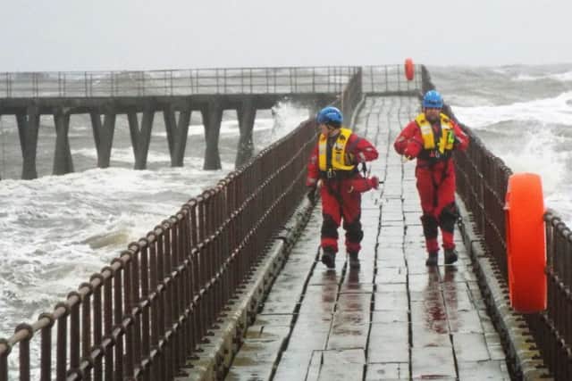 Coastguard rescue officers leave Blyth pier after checking an angler in the storms earlier this year. Picture by John Tuttiett