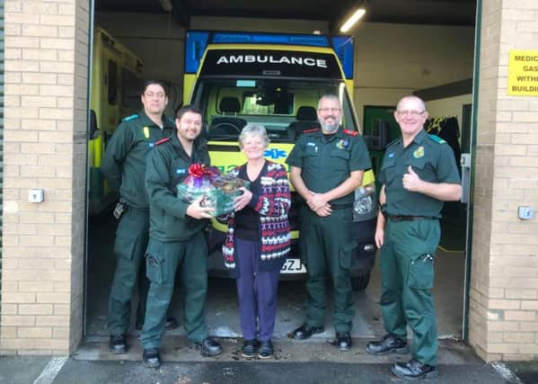 Morrisons community champion Margaret Kerr gives a Christmas hamper to members of the North East Ambulance Service.