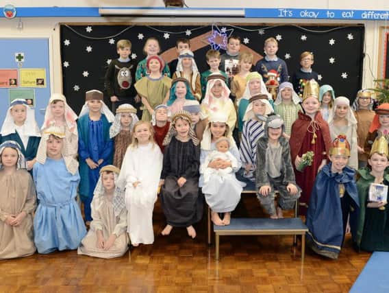 Children at Amble Links First School create a Nativity scene.