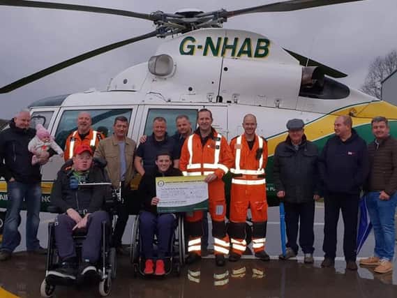 Sam Beecroft, Will Clark and members of the Toon to Town Challenge Group present a cheque to the Great North Air Ambulance Service.