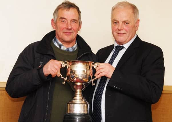 Michael Howie, from Morwick Farm, receives the Large Herds Trophy from judge Bruce Jobson.