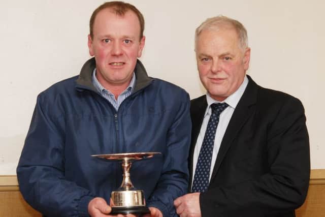 James Ogilvie, from Morwick Holsteins, receives the Herdsperson of The Year award from Bruce Jobson.