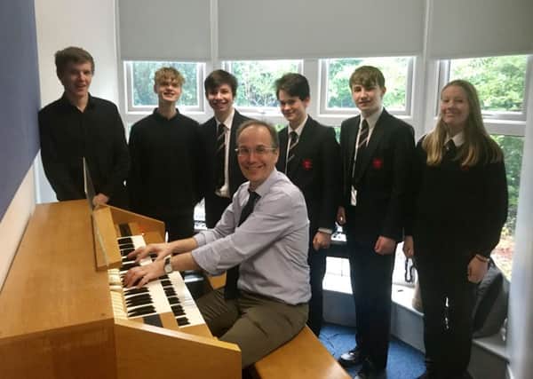 Robin Forbes, King Edward VI School head of music, and a group of students are pictured with the electronic organ.