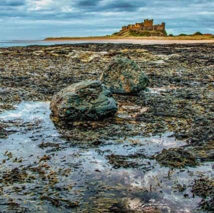 SECOND: Heavy skies over Bamburgh Castle and beach by Tony Robson (154 likes).
