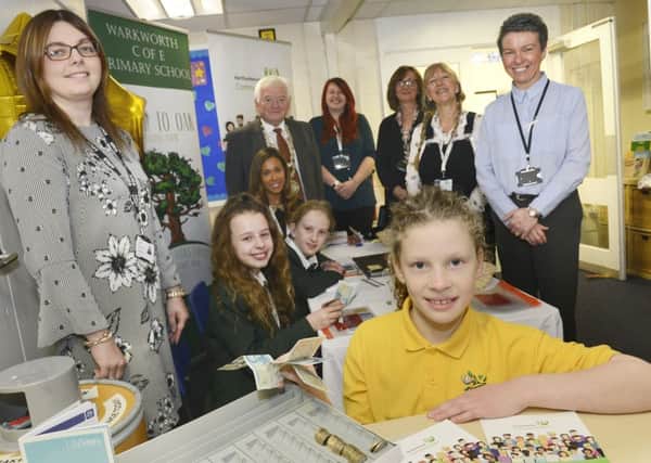 Delphine Currie, front, who came up with the name Acorn to Oak Bank with classmates, headteacher Laura Ritson, Coun Jeff Watson  who opened the bank, and representatives from Life Savers and Northumberland Community Bank at Warkworth Primary School. 
Picture by Jane Coltman