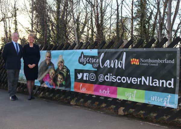 Coun Peter Jackson and Coun Cath Homer next to the advert at Morpeth Railway Station.