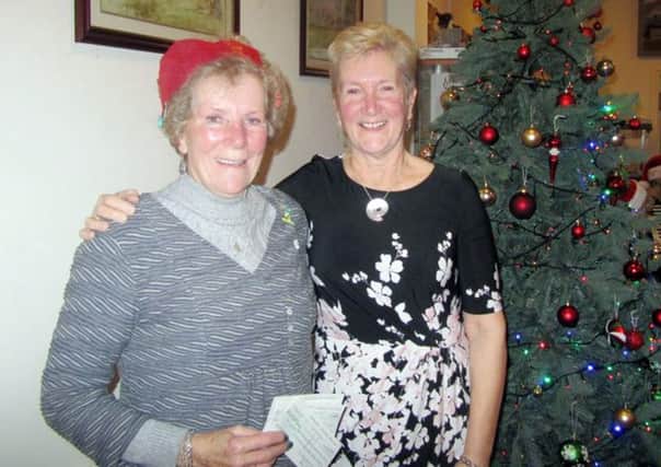 Lady captain Jan Steele from Rothbury Golf Club presenting a cheque to Audrey Jones for Â£1100 for the Great North Air Ambulance, Jan's chosen charity in her captain's year.