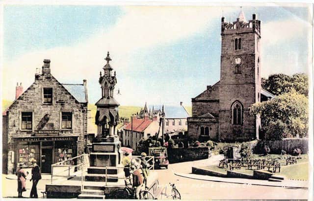 An old postcard showing the fountain in the centre of Wooler.