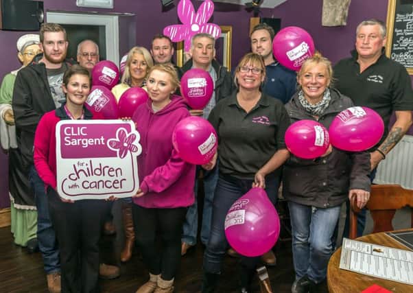 Celebrating the money raised for CLIC Sargent at the Village Inn, Longframlington. At the front with the sign are Dee Tyler, from CLIC Sargent, and Becky Cole.