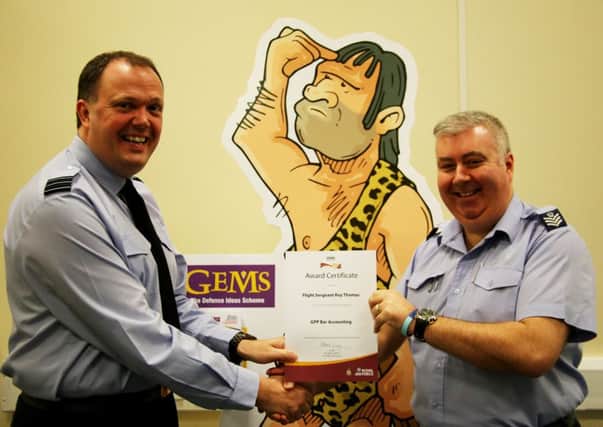 Wing Commanding John Booth presents Flight Sergeant Roy Thomas with his certificate.
