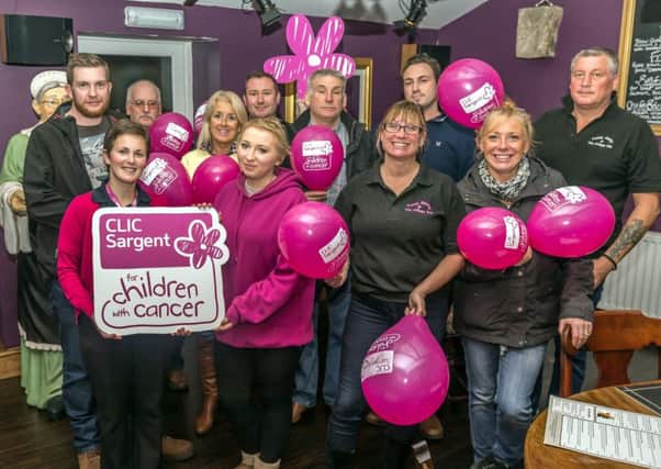 Celebrating the money raised for CLIC Sargent at the Village Inn, Longframlington. At the front with the sign are Dee Tyler, from CLIC Sargent, and Becky Cole.