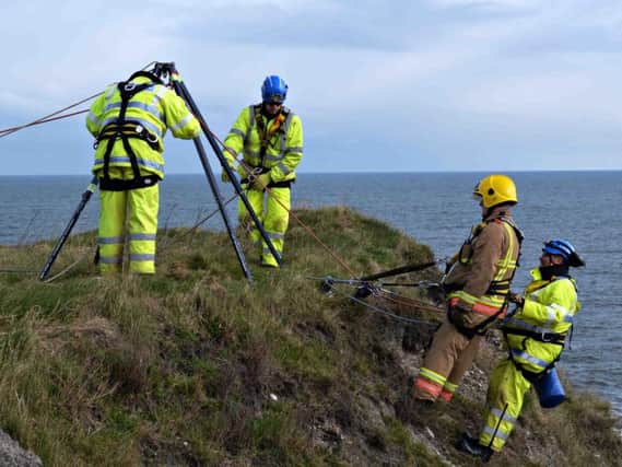 HM Coast Guard and Northumberland Fire and Rescue Service use specialist equipment to reach a pretend casualty on the bottom of a cliff.
