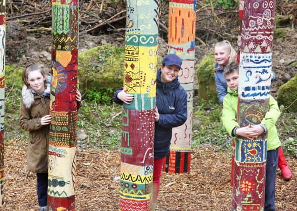 Abbie Hulme, Louise Short and Brook Miller with Isos community involvement team leader Sara Parker-Clark among the colourful totem poles.