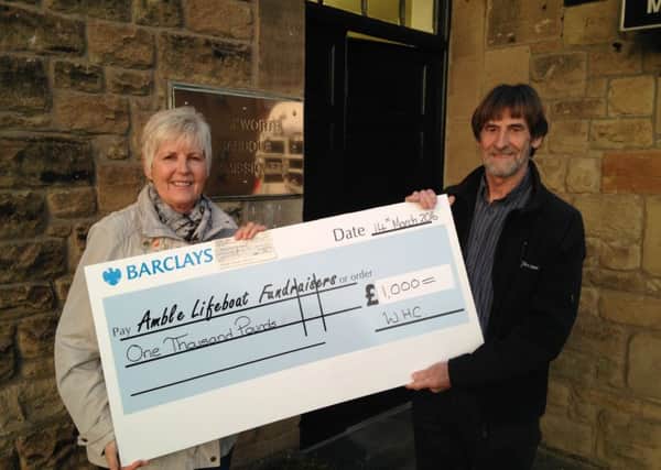 Maurice Burnett hands over the cheque to Linda Siney.