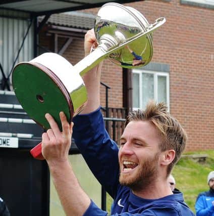 Amble Tavern's captain lifts aloft the NFA Justsport Sunday Cup after their win over Haltwhistle Jubilee in the final. Picture by Steve Miller