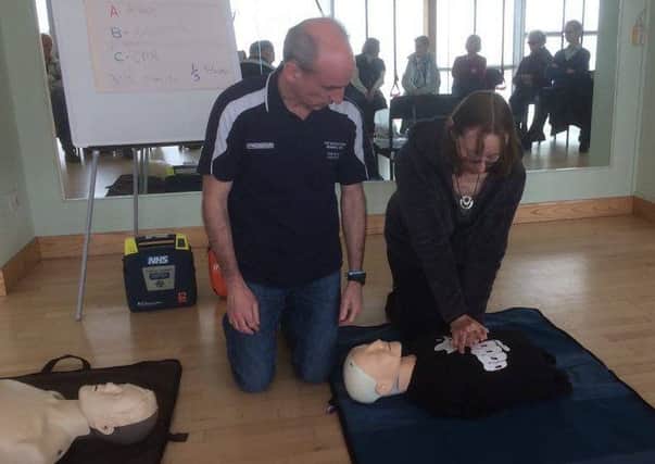 Margaret Vickers from Glendale Walkers learns CPR with Stephen Carey Fund representative Bryan Shendon.
