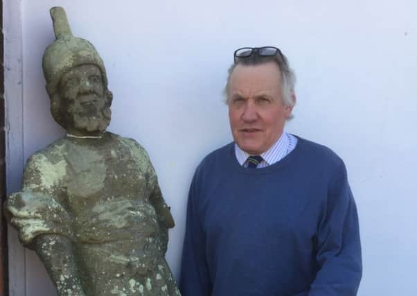 Jim Railton with the carved stone soldier, which will go under the hammer this weekend.