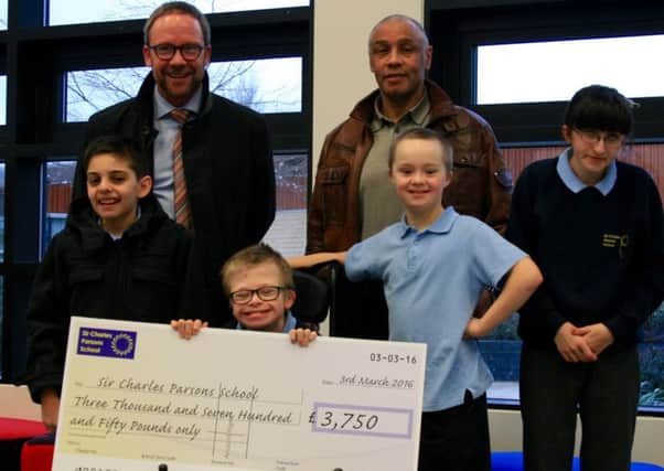 John Conway, left, and Paul Bine presenting a cheque in tribute to Jake Farley to pupils at Sir Charles Parsons School.