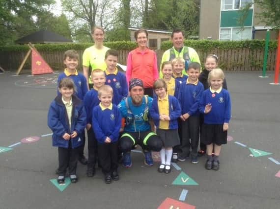 Ben Smith with pupils from St Michael's C of E First School and some of the runners in the support team.