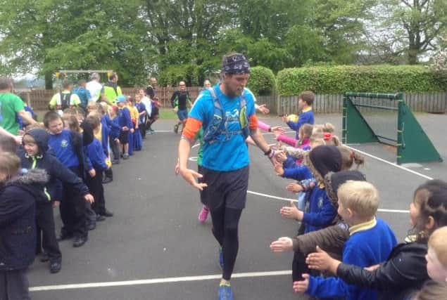 Ben Smith high-fives the pupils