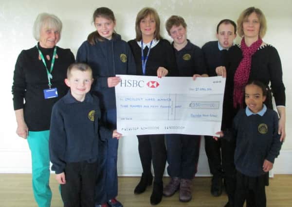 Gail Roper, centre, and pupils from the school present their donation to Catherine Johnstone, right, from the Alnwick oncology unit, and Anne Fletcher, left, Macmillan volunteer on the unit.