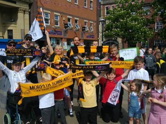 Morpeth Town fans gather in the Market Place to welcome back their heroes from the FA Vase triumph at Wembley. Picture by Jane Coltman