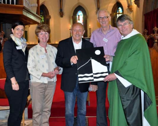 Poster artist Peter Drew, second from right, presents the original of his winning painting to the Vicar of St John's Church, the Rev Ian MacKarill. Picture by Terry Collinson