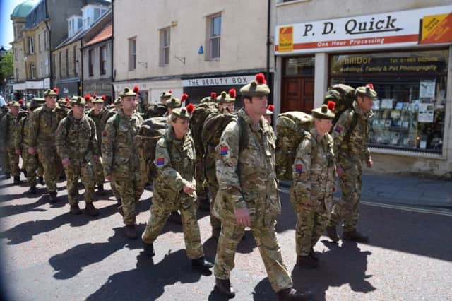 The troops march through Alnwick.