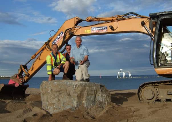 Volunteers uncover the stone on Newbiggin beach.