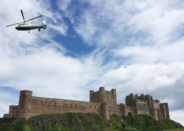 The Great North Air Ambulance over Bamburgh Castle.