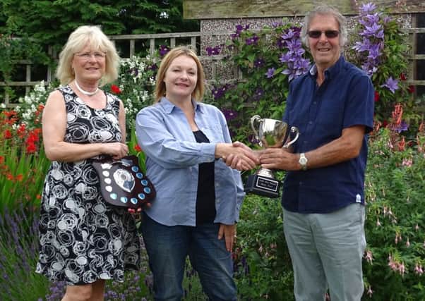 Mayor of Amble Jane Dargue, centre, presents June and Tony Carruthers with their prize for Best Overall Garden. Picture by Martin Horn