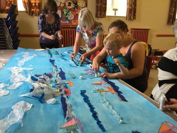 Children and parents at St Cuthbert's playgroup work on the seascape collage as part of the Tall Ships Community Art Project.