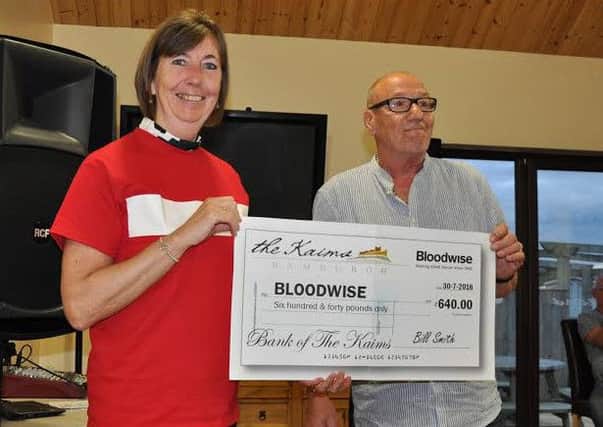 Helen Tait of Bloodwise receives a cheque for Â£640 from the caravan owners at Kaims Park, near Bamburgh.