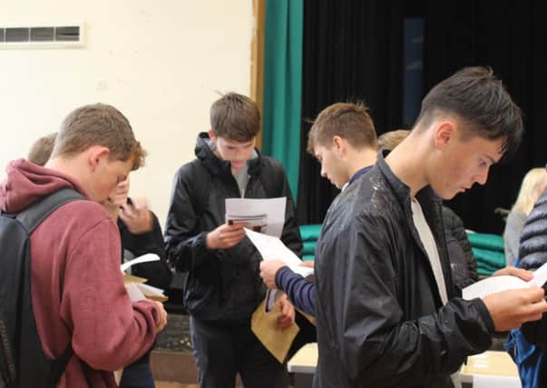 Some of the Year 11 King Edward VI School students examine their grades on GCSE results day. Picture by Lewis Jackson.
