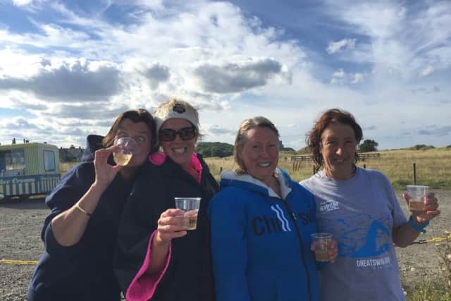 The 'mermaids' celebrate with a well-earned drink after completing the swim.