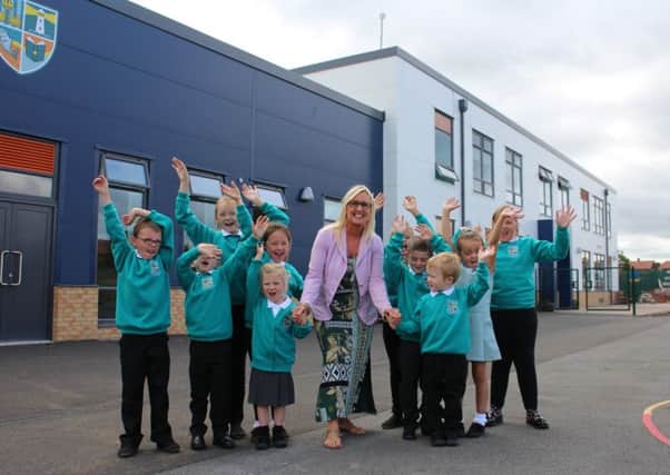 Year 2 teacher Miss Lewis with Whitehouse Primary School pupils outside their new building.