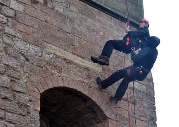 Ron Davies is helped by a member of the Adventure Northumberland team during his abseil.