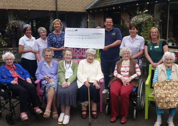 Staff and residents from Abbeyfield House in Alnwick receiving a cheque for Â£2,515 from Steve Miller, of AA Taxis.