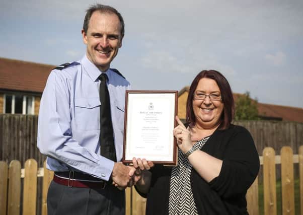 Air Officer Commanding Number 1 Group, Air Vice-Marshal Gerry Mayhew presents the Little Flyers childcare manager, Michelle Gascoigne, with his commendation.