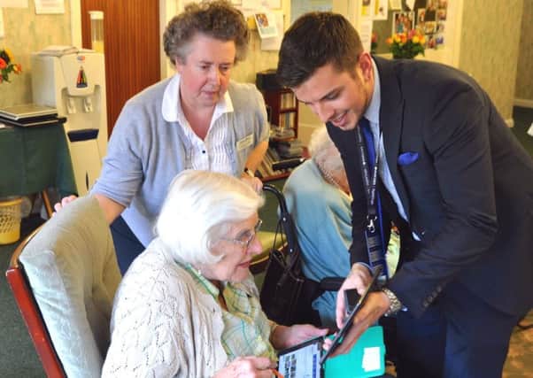 Barclays Digital Eagle Liam Senior shows Abbeyfield House residents in Alnwick that technology such as iPads can be easy to use and fun during International Older People's Day.