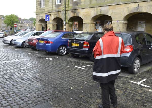 A civil enforcement officer checks the cars parked in Alnwick Market Place. 
Picture by Jane Coltman